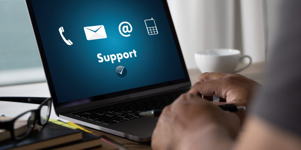 A person working at a laptop with IT support tools on screen